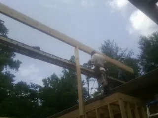 Carpenter setting a ridge beam over a new addition frame — Ice Dam Removal by Roofing Brothers in Cross Anchor