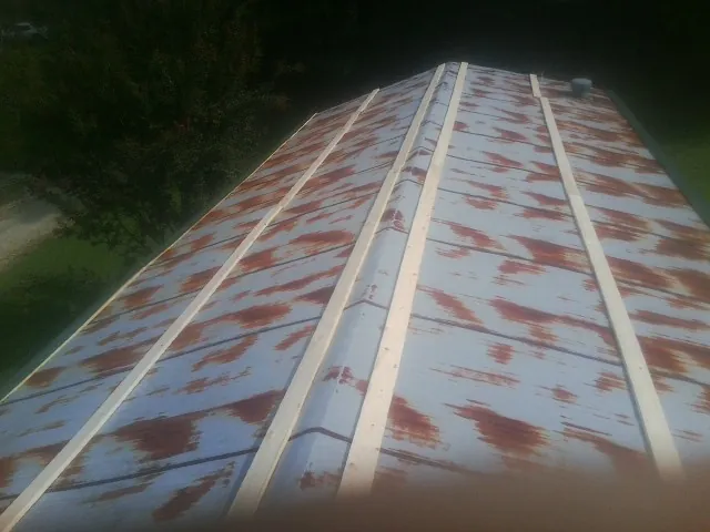 Rusted metal roof panels with new wood purlins before replacement — Storm Damage Roof Repair in Cross Anchor by Roofing Brothers