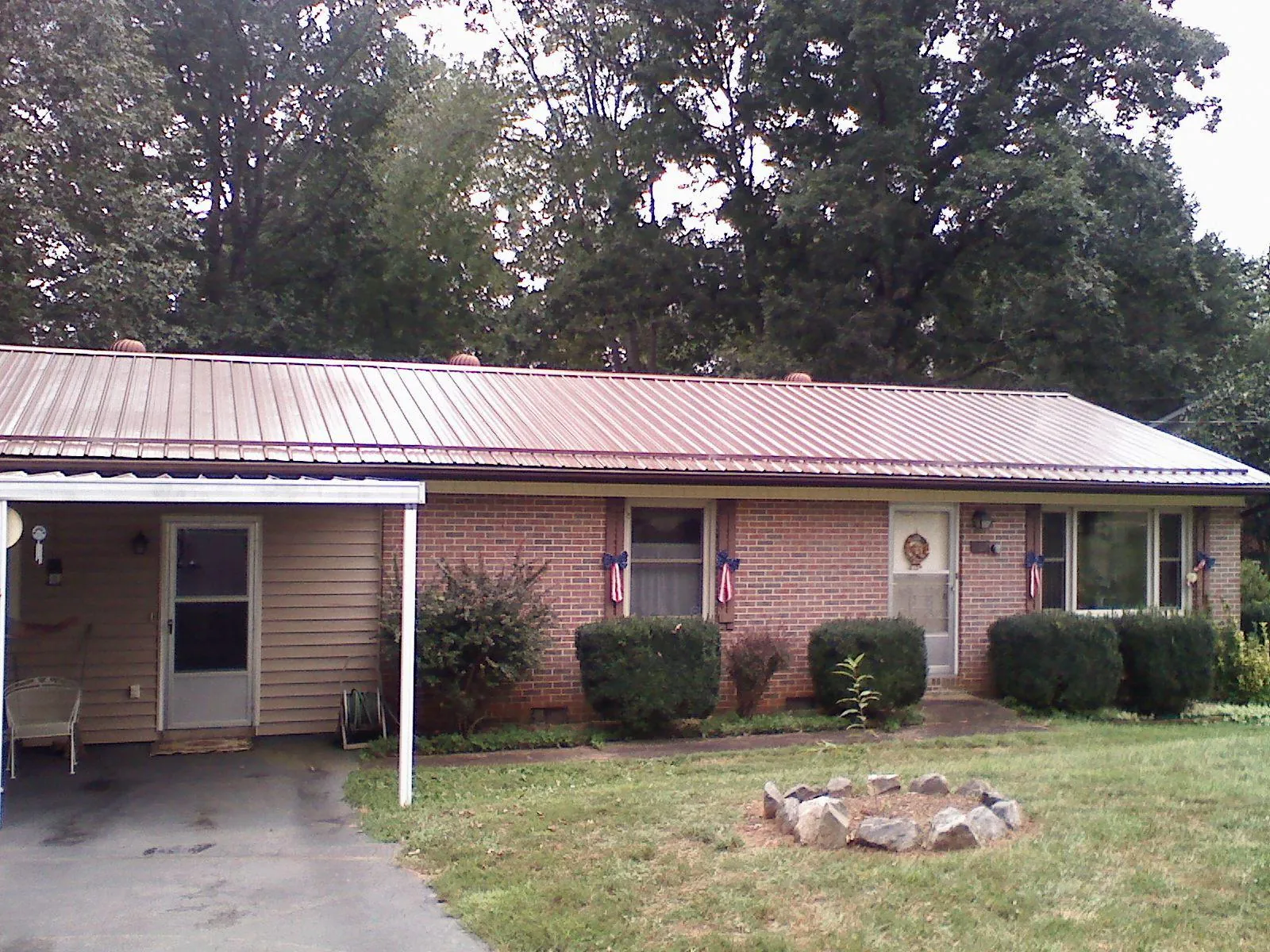 Bronze metal roof and carport on a brick ranch home — Roof Repair work by our crew in Cross Anchor